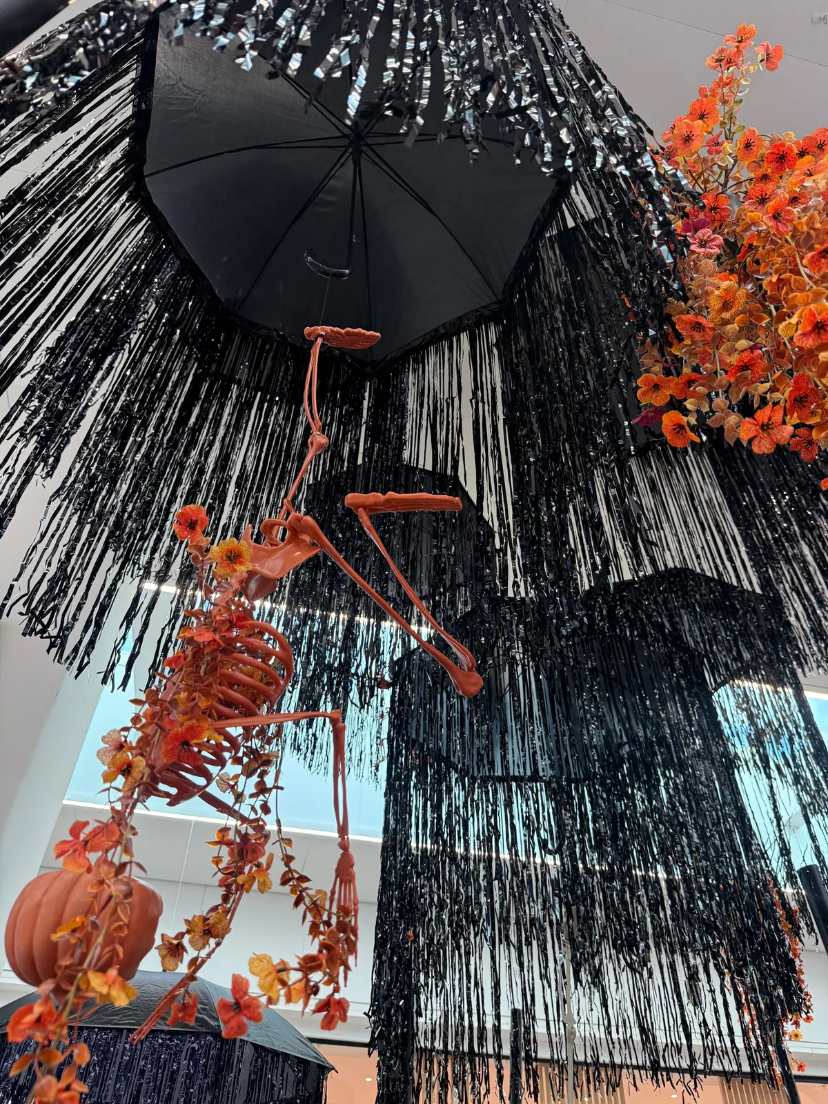 Parapluie noir à franges et guirlandes de feuillage d'automne