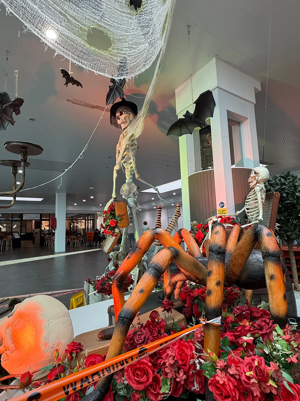 Araignée géante et squelette assis dans une composition de roses rouges